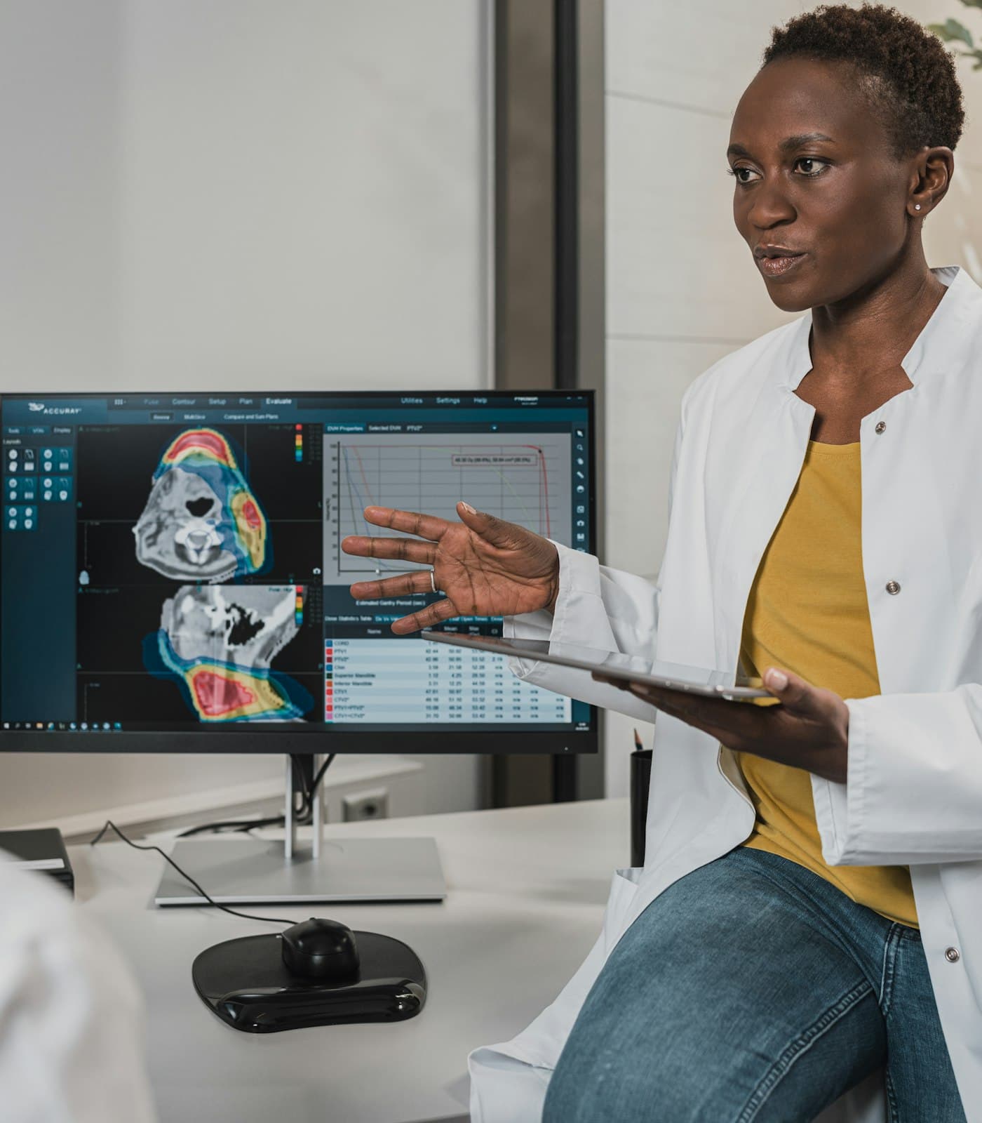 Physician reviewing patient data and reports on a tablet in a modern clinic